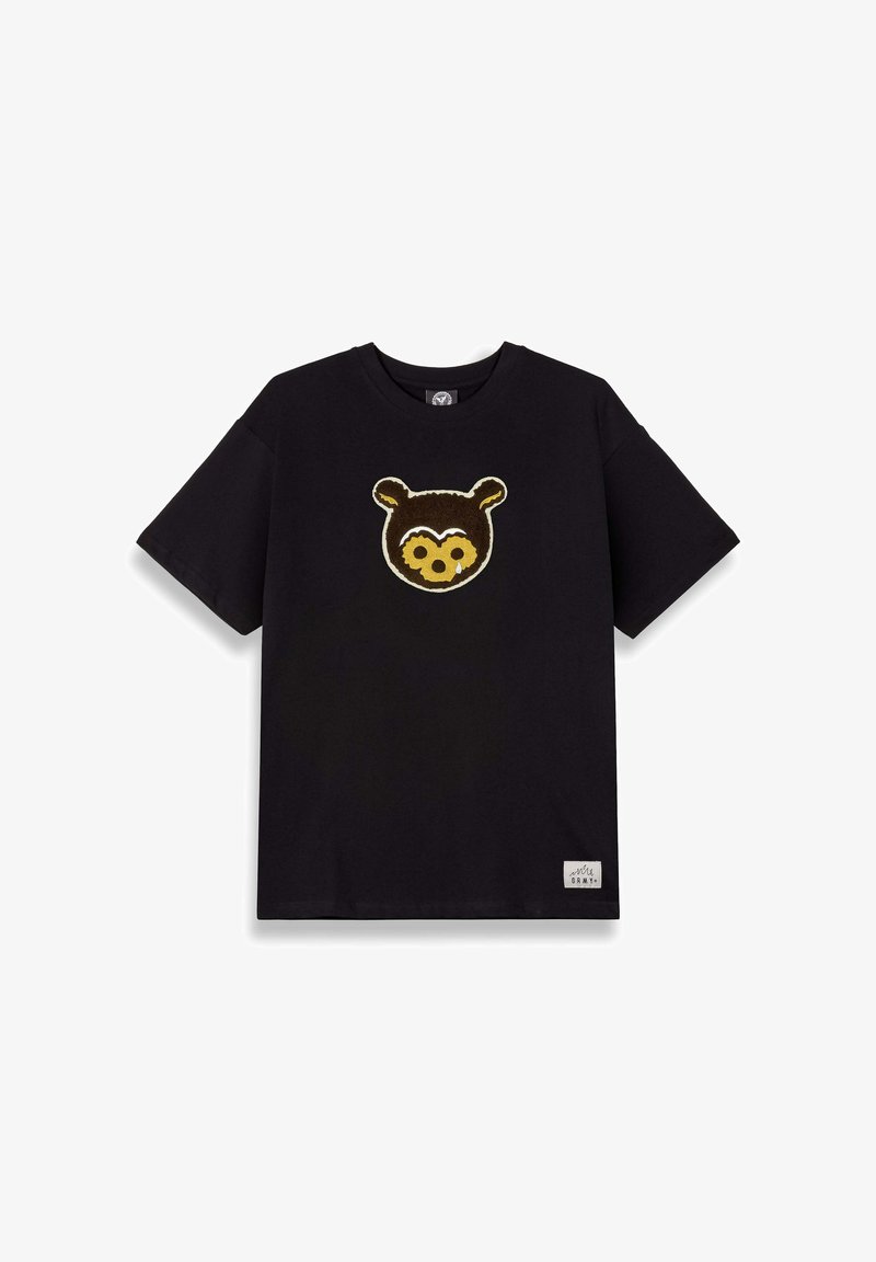 Camiseta de algodón negra con un aplique texturizado de la cara de un oso marrón en el frente. Mangas cortas, cuello redondo, con una pequeña etiqueta en el dobladillo.