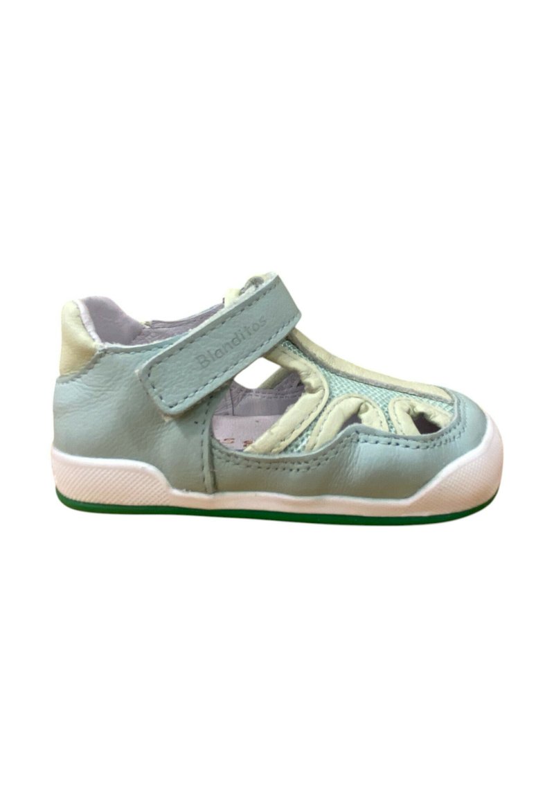 Zapato de cuero azul claro con diseño recortado, tira de velcro, suela de goma blanca y acentos texturizados; adecuado para niños.