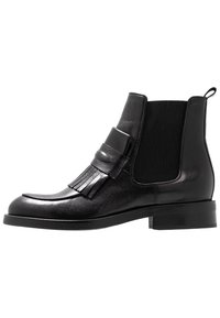 Černá kožená kotníková bota s kulatou špičkou, elastickými bočními panely, dekoračními třásněmi a nízkým blokovým podpatkem.