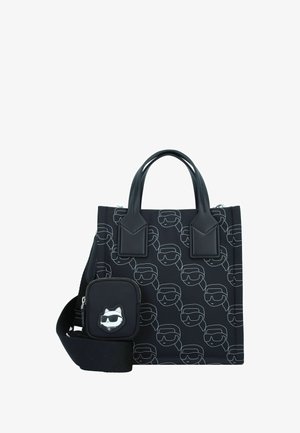 Bolso tote negro con un patrón de líneas blancas repetidas que representan rostros estilizados con gafas de sol. Incluye un pequeño bolso extraíble con un diseño de gato.