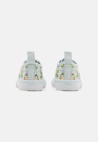 Blue canvas slip-on shoes with green cartoon characters, white rubber soles, and fabric pull tab at the back.