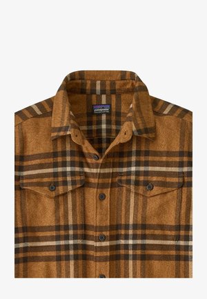Camicia a quadri marrone in cotone biologico. Presenta un colletto button-down, tasche sul petto e bottoni scuri. Il motivo include accenti crema e marrone scuro.