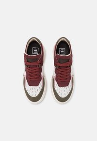 Sneakers met een kastanjebruin leren bovenwerk, witte geperforeerde leren neus, roze accenten en olijfgroene details. Beschikt over een vetersluiting en rubberen zool.