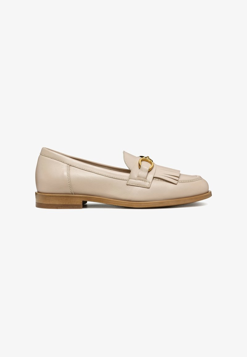 Mocassin plat en cuir beige avec un petit talon en bois, rabat avant à franges et détail de boucle métallique dorée sur le dessus.