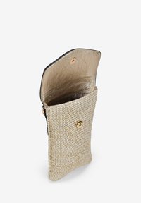 Bolso texturizado en color beige con un interior metálico dorado, con un borde negro y un cierre de botón dorado. Diseño compacto y flexible.