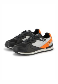 Baskets de sport noires et grises avec panneaux en maille en tissu et accents orange. Elles sont dotées d'un système de laçage et d'une semelle en caoutchouc pour une meilleure adhérence.