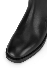 Fekete bőr bokacsizma sima felülettel, lekerekített orral és diszkrét varrási részletekkel a talp széle mentén.
