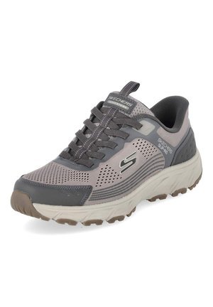 Sneakers Skechers Adventure sans lacets gris et beige avec empeigne en mesh, détails lacets et semelle en caoutchouc texturée pour une utilisation en extérieur.