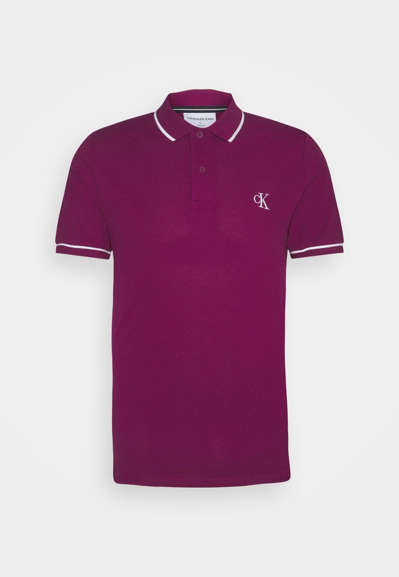 Polo bordeaux avec bordure blanche, doté d'un col, d'une patte de boutonnage et du logo CK brodé sur la poitrine gauche. Matière en coton doux.