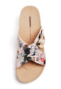 Sandale à glissière florale avec des brides croisées en tissu rose clair ; présente une semelle intérieure texturée et un accent doré sur le côté.