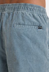 Shorts en velours côtelé bleu clair avec une texture côtelée, une taille élastique et une poche arrière avec une petite étiquette de marque.