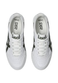 Bílé sportovní boty s zelenými akcenty, hladký kožený svršek, kulatá špička, perforované detaily a šněrování. Název značky viditelný uvnitř.