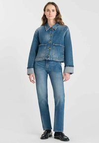 Denimjacka med krage, knappstängning och två framfickor; bärs över matchande jeans; allt i en medelblå tvätt med en avslappnad passform.