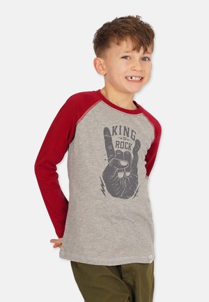 Graues Langarm-T-Shirt mit roten Raglan-Ärmeln, das ein schwarzes Grafikdesign zeigt, auf dem eine Hand das Rock-Zeichen macht, sowie den Text "KING OF ROCK."