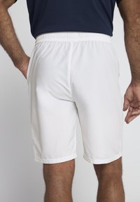 Weiße Sportshorts aus glattem Stoff, mit einem elastischen Bund und Seitentaschen, im geraden Schnitt und mit gesäumten Kanten.