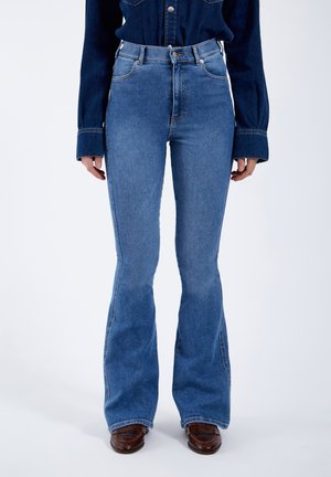 High-waisted blue denim flared jeans with a light wash, featuring a five-pocket design and belt loops. Smooth texture and structured fit.
