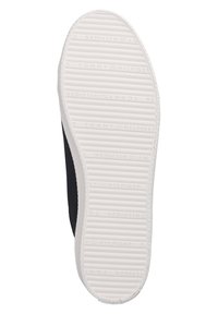 Suela de una zapatilla; goma blanca con textura canalada. Parte superior de textil negro duradero con borde blanco cosido. Logotipo de la marca impreso en la suela.