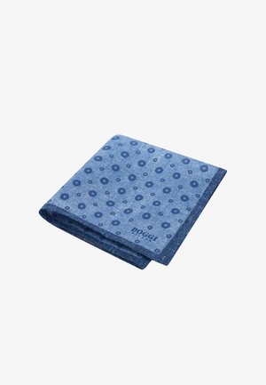 Pañuelo azul plegado con patrones circulares en azul oscuro y un logo "HOGGI" en el borde.