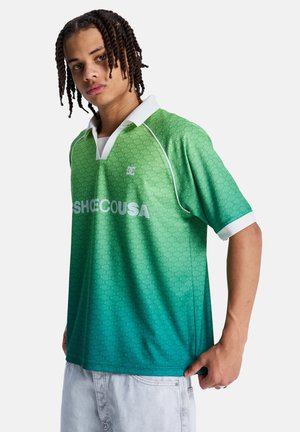 Zielona koszulka polo z gradientem i teksturowanym wzorem, z białym kołnierzykiem i napisem z logo na przodzie. Tkanina wydaje się gładka i lekka.
