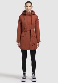 Roodbruine parka met een capuchon, knopen aan de voorkant, trekkoorden en een ceintuur in de taille. Beschikt over zijzakken en een gestructureerde stof.