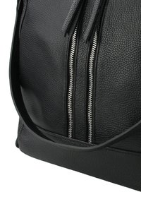 Sac à main en cuir noir avec une surface texturée, comportant deux compartiments zippés argentés et une bandoulière robuste.