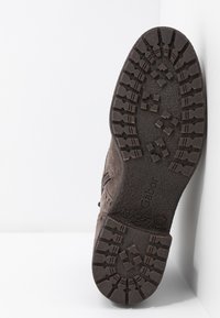 Bottine en daim marron avec une semelle en caoutchouc texturée dotée d'un profil à motifs et d'une fermeture éclair sur le côté pour un enfilage facile. Logo "Gabor" moulé sur la semelle.