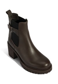 Bruine leren enkellaars met een blokhak, elastische zijkanten en een decoratieve gesp. Gladde afwerking met een gestructureerde rubberen zool.