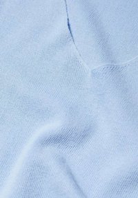Tissu tricoté bleu clair avec une texture côtelée fine et un décolleté en V, présentant de légers plis naturels.