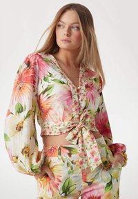 Bloemmotief cropped blouse met lange ballonmouwen, met roze, gele en groene patronen, met een strikdetail in de taille.