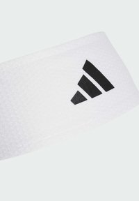 Biały sportowy opaska na głowę z teksturowanym materiałem, z czarnym logo Adidas w trójkątnym wzorze z boku.