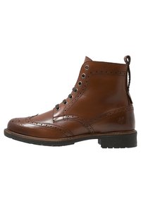 Brune læder ankelstøvler med brogue-detaljer, rund tå, seks øjesting lukning og en pull-tab bagpå. Flad sål.