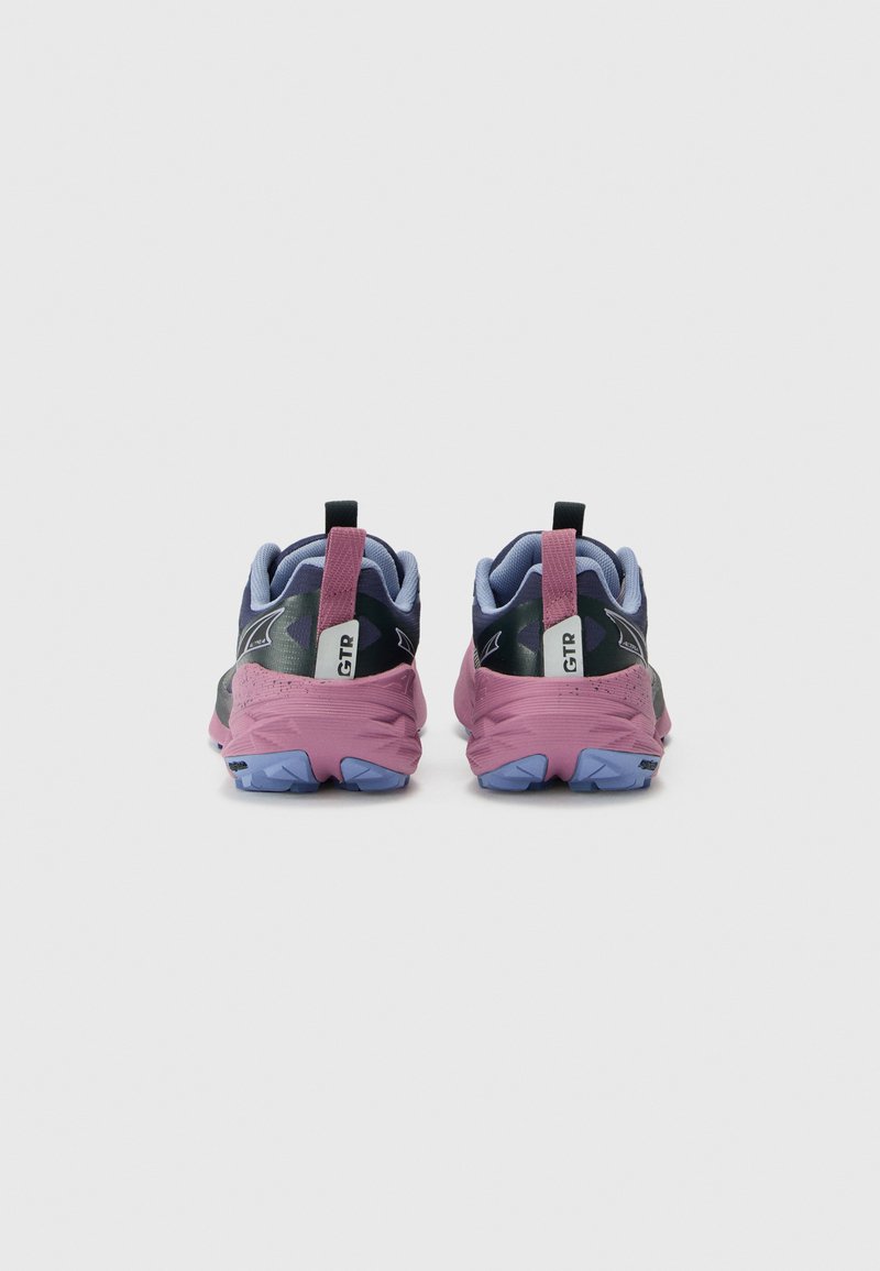 Zapatillas de trail running con un diseño en negro y púrpura, material de malla y sintético, suela texturizada y tirador para ponerlas fácilmente.