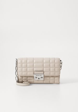 Gepolsterte beige Leder-Umhängetasche mit silbernem Zubehör, ausgestattet mit einem magnetischen Verschluss und einem abnehmbaren Kettenriemen.