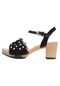 Sandalette nera in suede con tacco alto, decorazioni floreali, dettagli in perle, cinturino alla caviglia regolabile e tacco a blocco in legno.