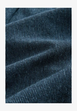 Modrý pruhovaný látkový materiál s střídajícími se tmavě modrými a světlými modrými pruhy. Textura je měkká, s hladkým a mírně reflexním povrchem.