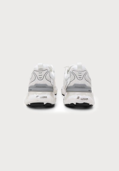 Ζευγάρι λευκά και γκρι sneakers με παχιά σόλα και το όνομα της μάρκας Dsquared2 ορατό στη φτέρνα, εμφανίζονται από πίσω σε λευκό φόντο.