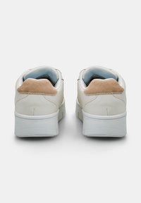 Baskets en cuir blanc avec un contre-orteil en suède beige et un col rembourré bleu. Semelle épaisse blanche avec surface texturée. Design minimaliste.
