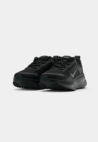 Crne trkaće tenisice s teksturiranim gornjim dijelom, vezanjem i podstavljenom podlogom. Istaknuti Nike logo i guma na potplatu za prianjanje.