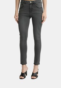 Jeans a vita alta, slim-fit in denim grigio scuro. Presentano tasche frontali, una chiusura con cerniera e cuciture minimaliste lungo i bordi.