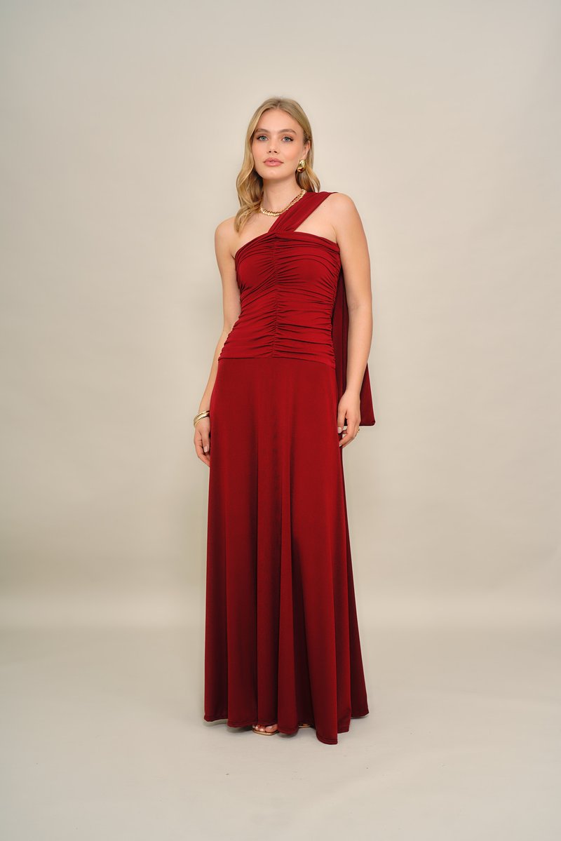 Κόκκινο βραδινό φόρεμα με ένα ώμο, με πιετά και ρυτιδωτές λεπτομέρειες, μακριά φούστα μέχρι το πάτωμα και απαλό, ελαστικό ύφασμα. Κομψή πτύχωση στον ώμο.
