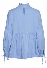 Blouse bleu clair à manches longues avec col haut volanté, bouton en forme de gouttière dans le dos, taille froncée et poignets noués sur des manches amples.