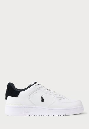 Witte leren sneaker met zwarte suede accenten, vetersluiting, geperforeerde neus en een klein geborduurd logo aan de zijkant.