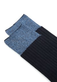 Calze a maglia con una texture a coste nera nella parte inferiore e una parte superiore con un motivo blu marmorizzato. Il design include un blocco di colore contrastante.