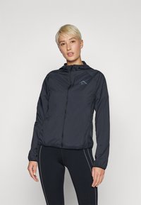 Lagani crni zip-up bundić s kapuljačom, s plavim logotipom na lijevoj strani prsiju, elastičnim manžetama i opuštenim krojem.