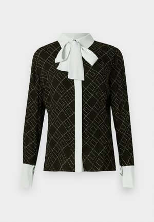 Blusa preta de mangas longas, com colarinho branco em forma de laço, frente com abertura de botão branca e um padrão geométrico costurado. Punhos brancos com botão.