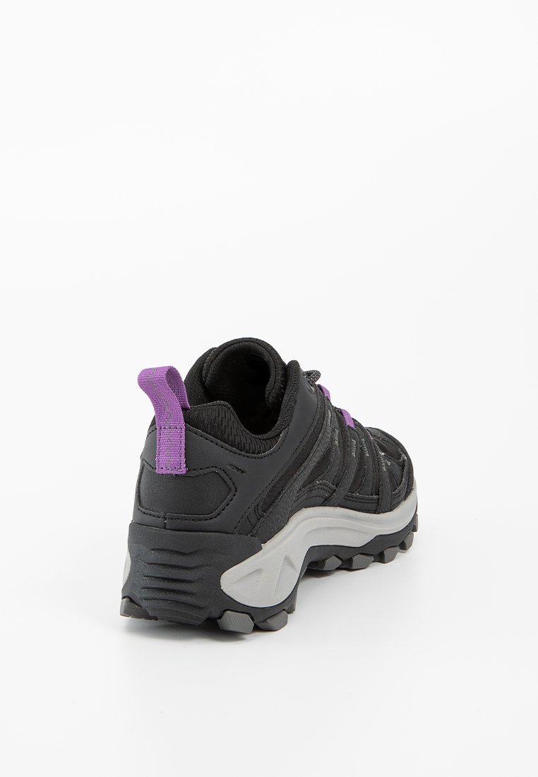 Zapato de senderismo negro con acentos morados, material superior texturizado, cuello acolchado y suela de goma gris resistente diseñada para proporcionar tracción.