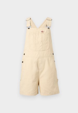 Beige katoenen korte overalls met verstelbare bandjes, een borstzak aan de voorkant, knopen aan de zijkant en een klein merkembleem boven de zak.