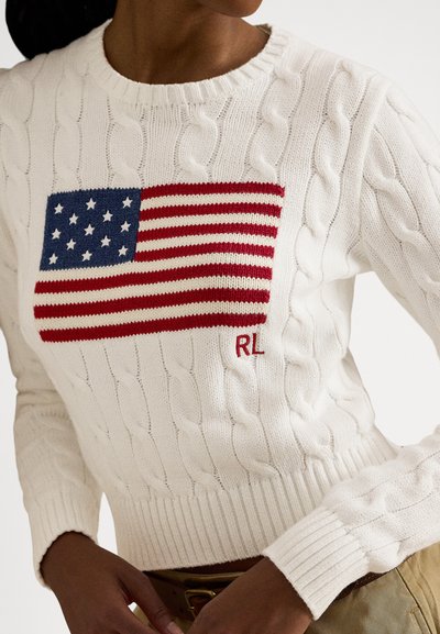 Beli pulover z vzorcem kitke, na katerem je izvezena ameriška zastava z rdečimi črtami in modrim poljem, okrašen z majhnim rdečim logotipom "RL".