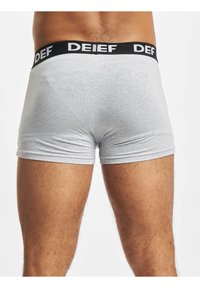 Gray boxer shorts made of a soft material featuring a black waistband with white lettering. The design is fitted with a smooth texture.