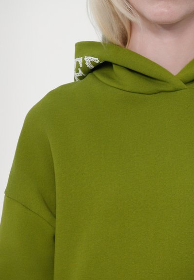 Olivgrön hoodie med en mjuk textur, som har en dragsko på huvan och en ljusfärgad dekorativ accent vid halsringningen.